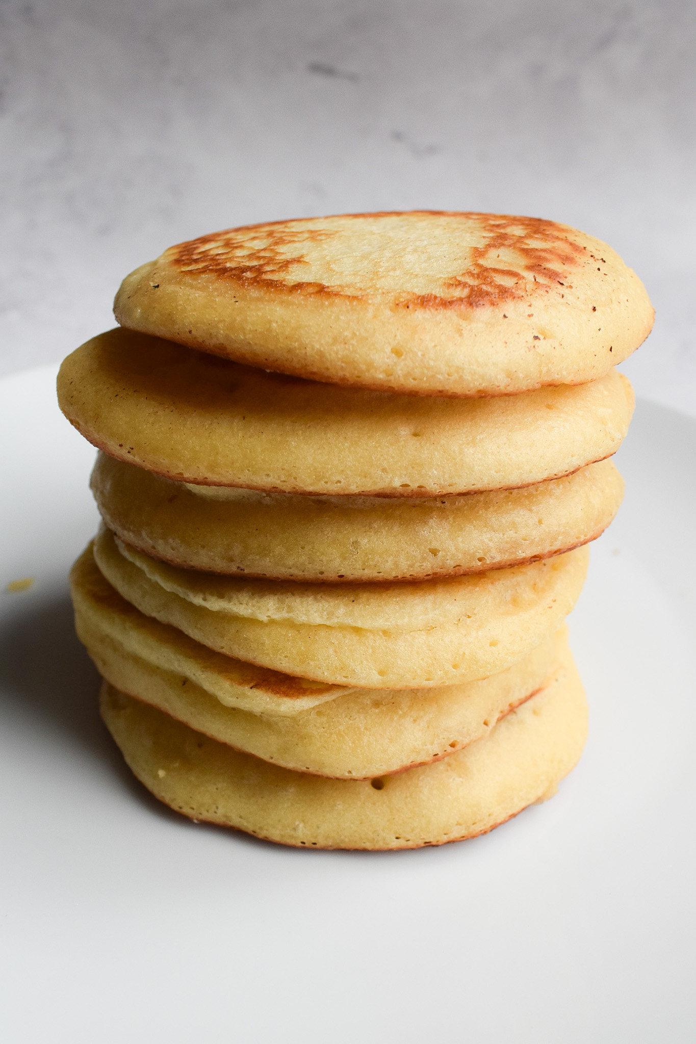 Stack of fluffy pancakes from side view.