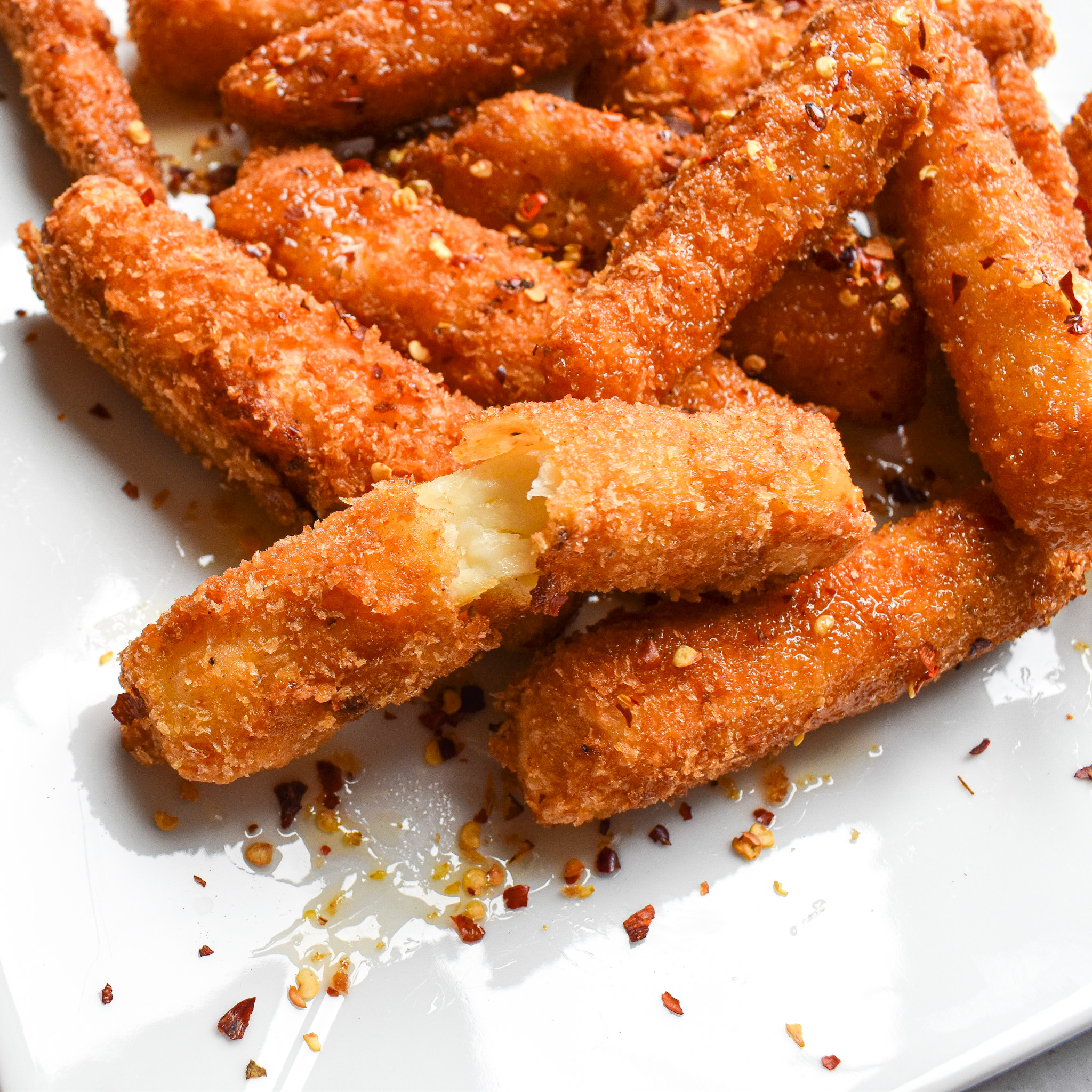 a bunch of halloumi fries with one of the fries broken in half to reveal the soft cheese.