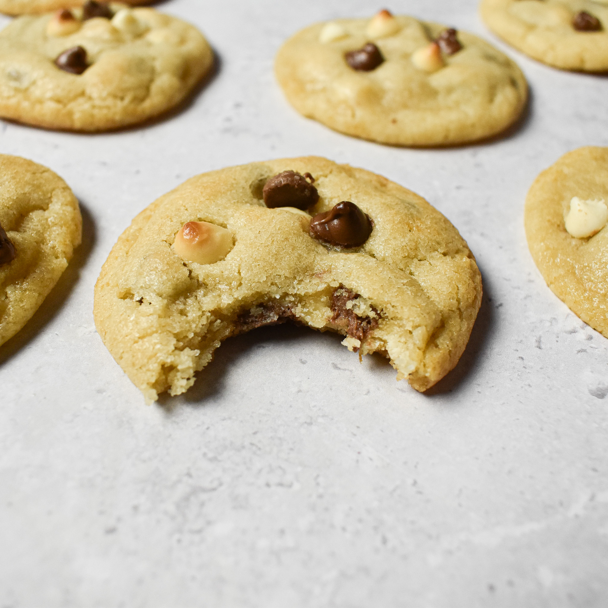 mini white and milk chocolate chip cookie with a bite taken