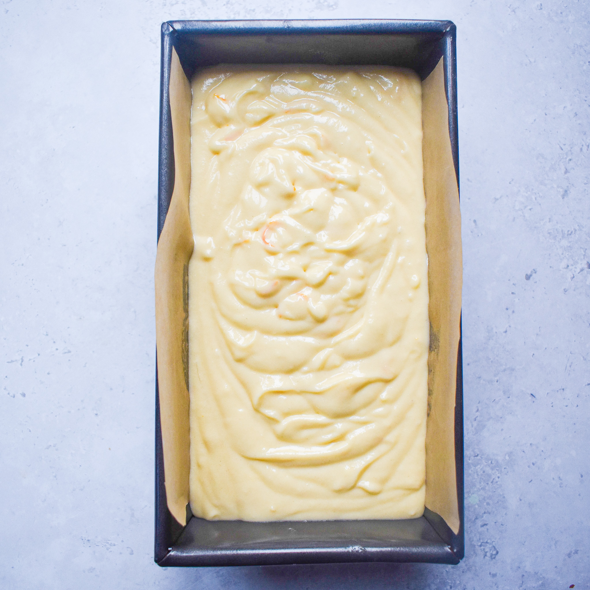 orange cake batter in tin